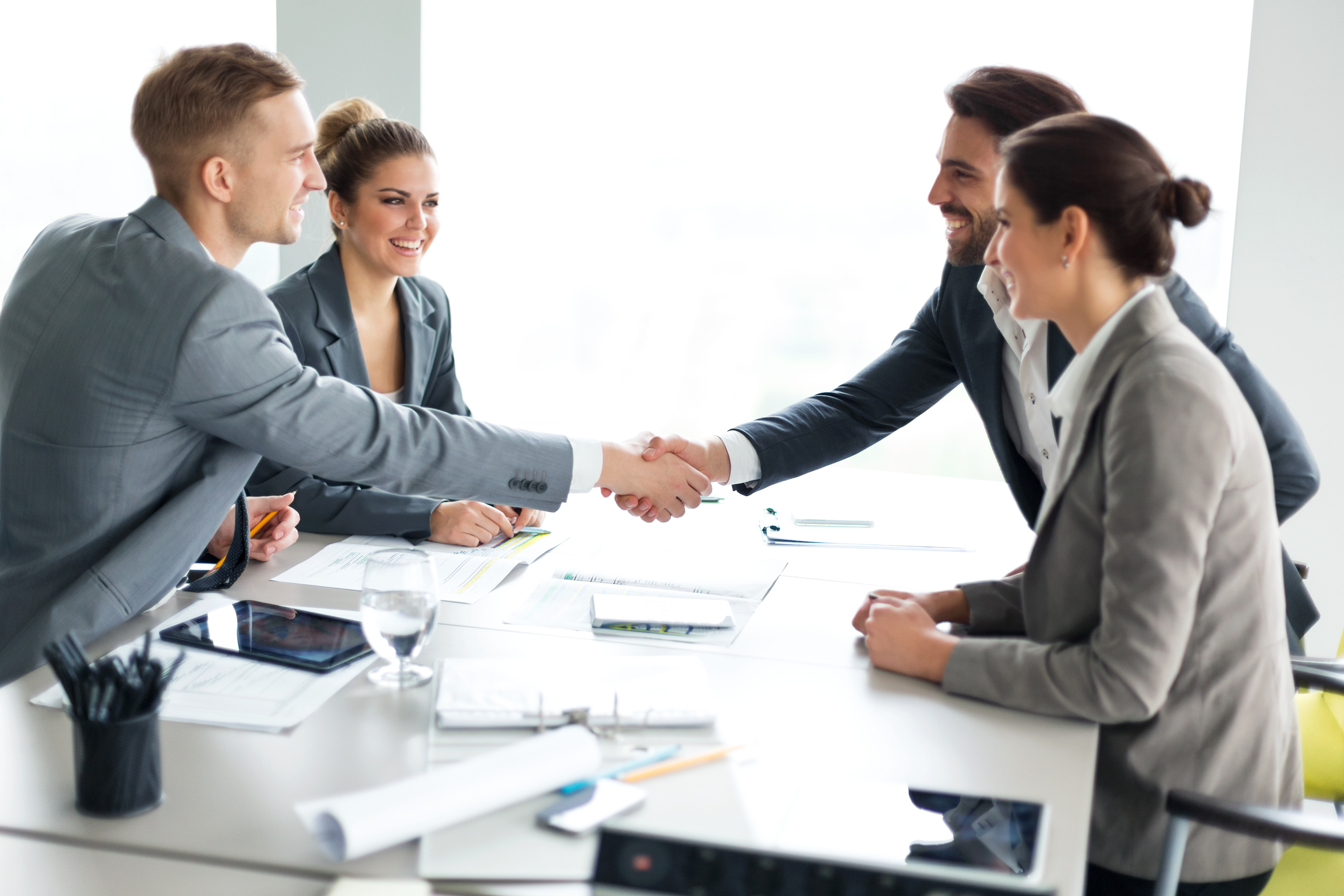 Couple on a meeting with their financial advisor, shaking hands in agreement